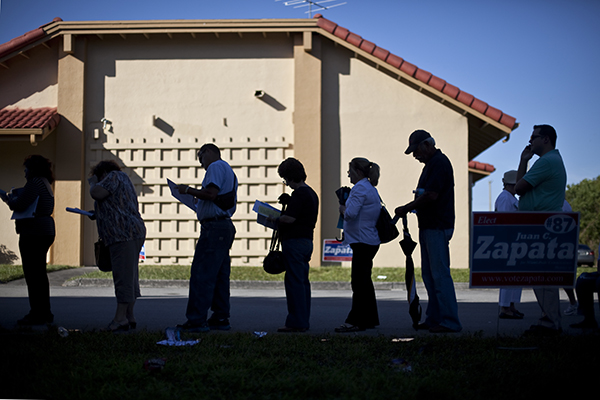 People lined up outside of West Kendall Regional Library, Precinct #762, on Tuesday afternoon to vote. While waiting in line they were each given a sample ballot and the supporters of local candidates passed out literature. Monica Herndon // Assistant Photo Editor