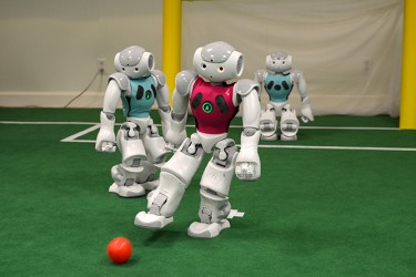 The robots, created by a team of PhD students at the University of Miami have been programmed to kick a ball by themselves and interact with other "players," simulating a soccer game. Becca Magrino // Contributing Photographer