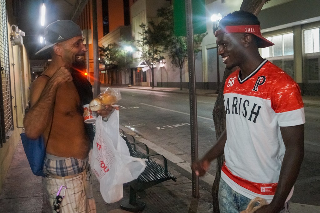 “My name is Albert, you know like Fat Albert?” Originally from The Bronx Albert, 45, receives a free meal from Billah Abdul-Jalaal Sunday night in Downtown Miami. During their conversation, Albert told Billah about the hard life he’s faced, displaying the numerous stab wounds and burns from drug handling. Nadijah Campbell // Contributing Photographer