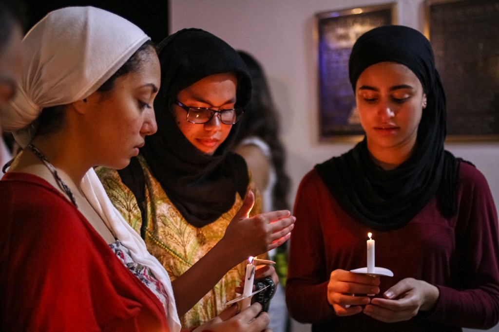 Sophomore Rowanne Ali, junior Areeba Imam, and sophomore Aya Eltantawy, vice president, president and treasurer of the Muslim Students' Association (MSUM), gather together during the candlelight vigil Wednesday evening at the UC Breezeway. The vigil was organized by the Council of International Students and Organizations (COISO) to encourage support and remembrance of those impacted by the recent acts of terror around the world. Erum Kidwai // Staff Photographer