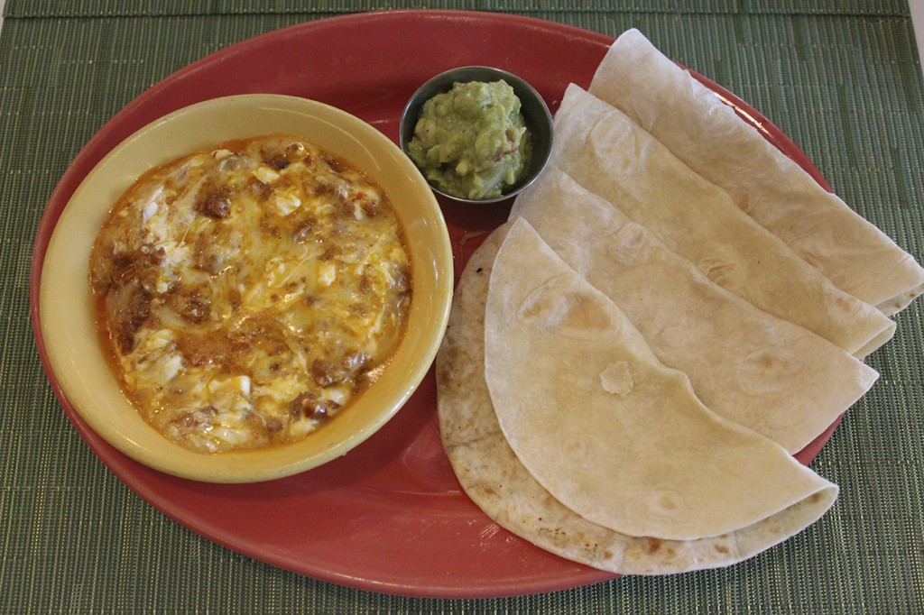 The Queso Fundido Con Chorizo at Wapo Taco combines oaxaca cheese fondue with crumbled mexican sausage and is served with warm flour tortillas and guacamole. Hallee Meltzer // Photo Editor