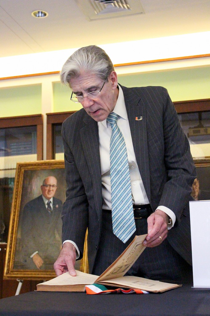 President Frenk peruses the first published Ibis Yearbook, which is featured in an archives exhibit during the Firsts at UM event Wednesday evening in the Newman Alumni Center. Hallee Meltzer // Photo Editor