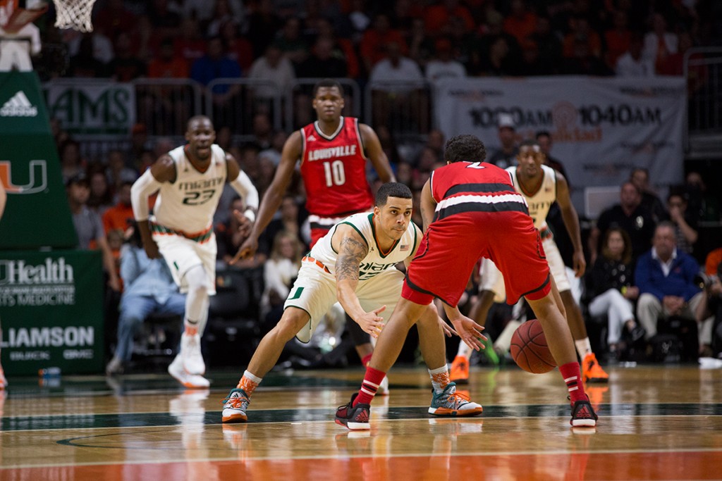 Redshirt senior guard Angel Rodriguez (13) defends the Louisville point guard at the BankUnited Center in a 73-65 win for the Canes. Nick Gangemi // Editor-in-Chief
