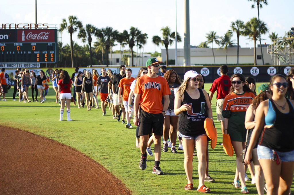 Seniors walk along the baseball field at Alex Rodriguez Park at Mark Light during the Senior Walk hosted by Category 5 Friday night. Kawan Amelung // Staff Photographer