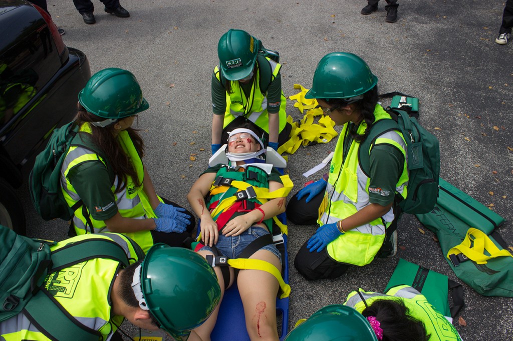 Members of CERT attend to a participant on a stretcher after removing her from a simulated car crash Sunday morning during the CERT Disaster Readiness Exercise. Giancarlo Falconi // Staff Photographer