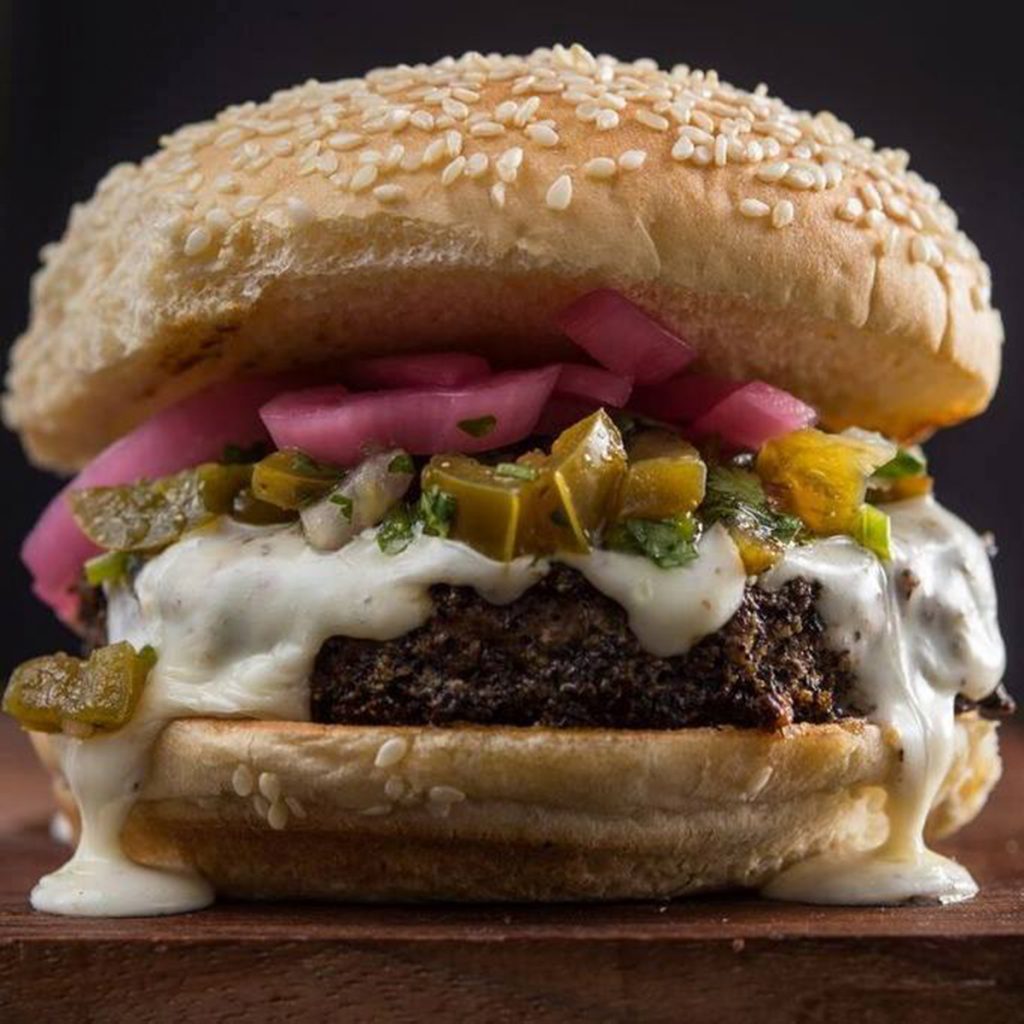 The New Mexico burger from Bobby's Burger Palace features queso sauce, roasted green chiles, and pickled red onions. Photo courtesy Bobby's Burger Palace