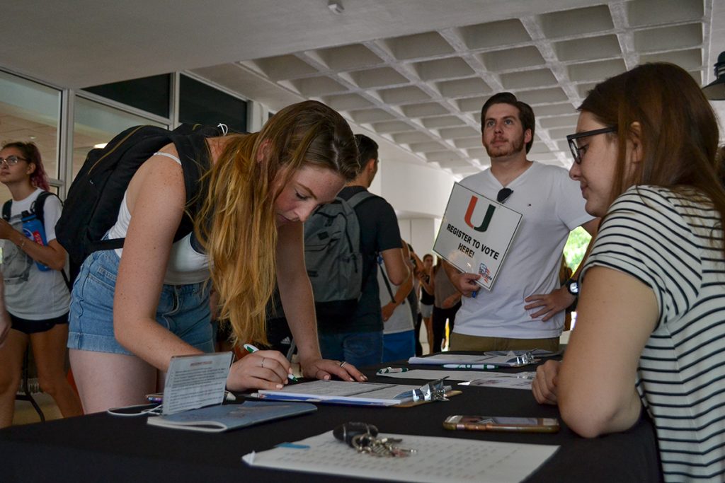 Sophomore Ralph Paz and junior Tess Schuit encourage students to register to vote during Get Out the Vote's tabling Wednesday afternoon in the UC Breezeway. Amanda Prats // Contributing Photographer