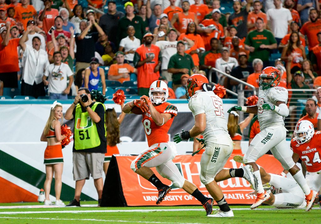 Junior wide receiver Braxton Berrios (8) runs past FAMU defenders for a touchdown during the Hurricanes’ 70-3 win at Hard Rock Stadium. The Canes are anticipating their game against FAU this Saturday. Joshua White // Contributing Photographer