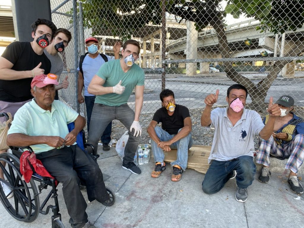 The Levine brothers pose alongside others wearing their masks during distribution on Sunday, May 4.
