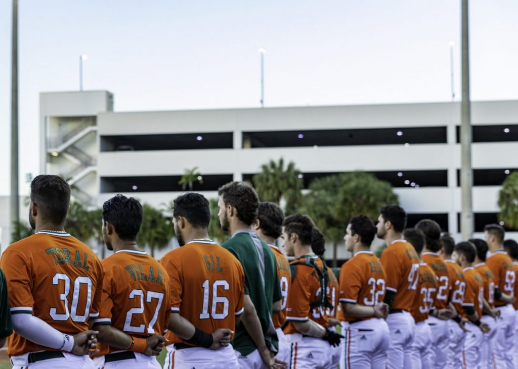 Members of the Hurricanes Baseball team line up for the national anthem before their game versus Kent State on Feb. 19, at Mark Light Field in Coral Gables, FL.