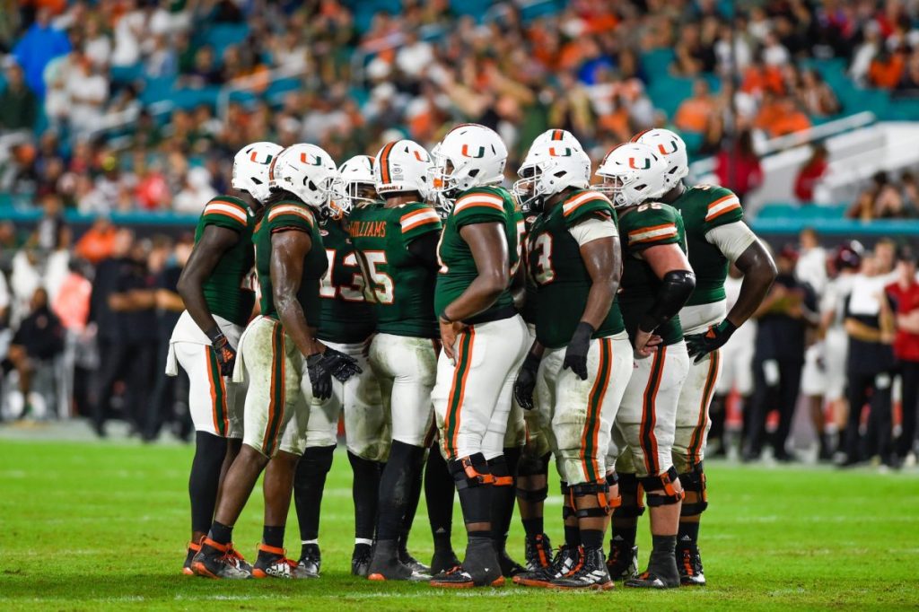 ‘Canes football players huddle during Miami’s game versus Louisville at Hard Rock Stadium on Nov. 9, 2019. The Hurricanes beat the Cardinals 52-27.