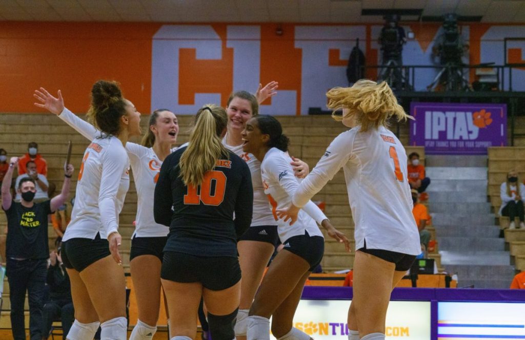 Members of the Canes Volleyball team celebrate after sweeping the Clemson Tigers in the Jervey Athletic Center in Clemson, South Carolina on Friday, Oct. 9.