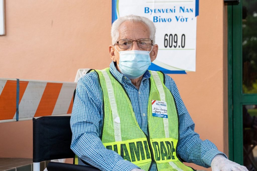 Silvio Cordova, a deputy poll worker, sits at the entrance to the Coral Gables Community Center on Tuesday, Nov. 3.
