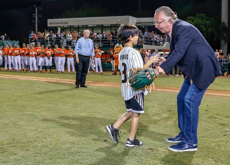 Morris congratulates his son, Will, after he throws the ceremonial first pitch after Morris’ jersey number retirement ceremony in 2019. Known as Number 3, the longtime coach now prioritizes being a family man.