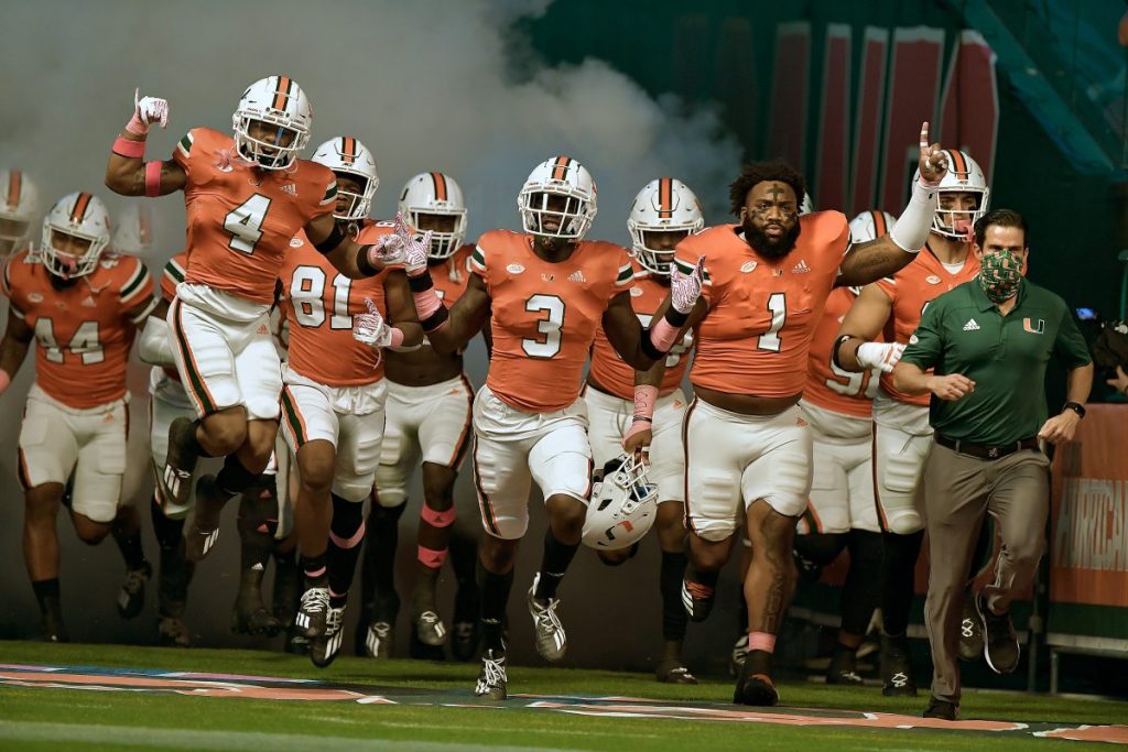 The Miami Hurricanes run on the field before their game versus Virginia on Oct. 24, 2020.