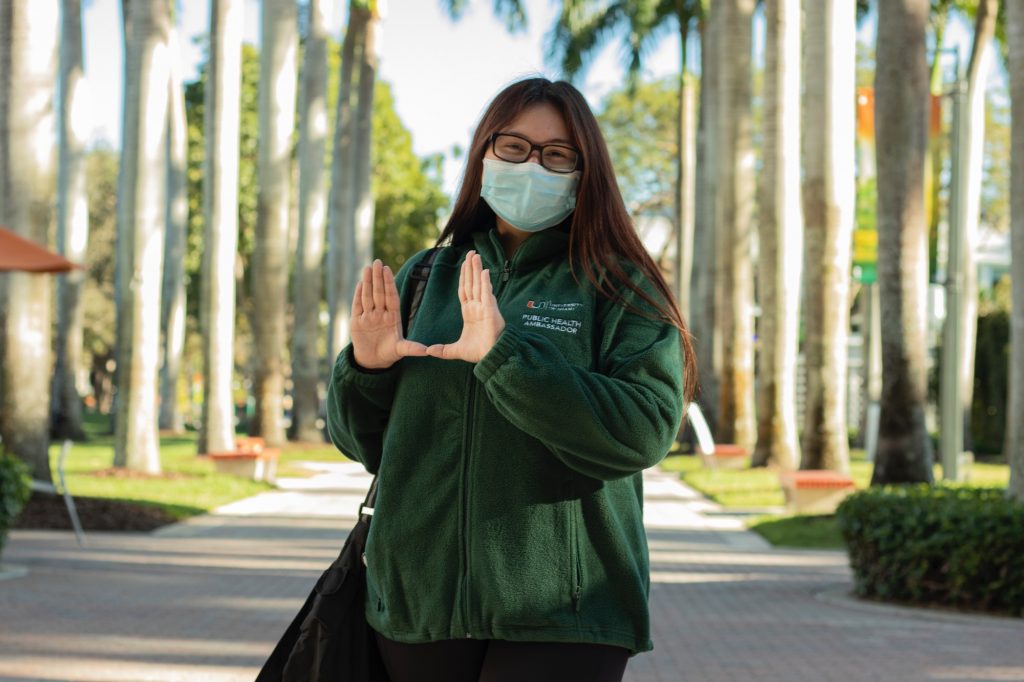 Freshman Public Health Ambassador Maddie Shewmaker throws up the “U” outside of Richter Library on Feb. 3. PHAs are assigned  to five different zones on campus.