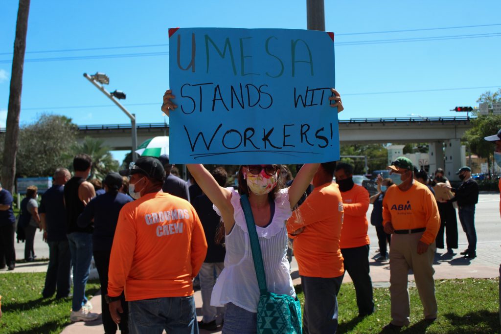 A member of UMESA protests the current working conditions of the ABM janitorial staff Feb. 26. Protesters began at St. Bebe Episcopal Chapel and marched to Ponce De Leon Boulevard.