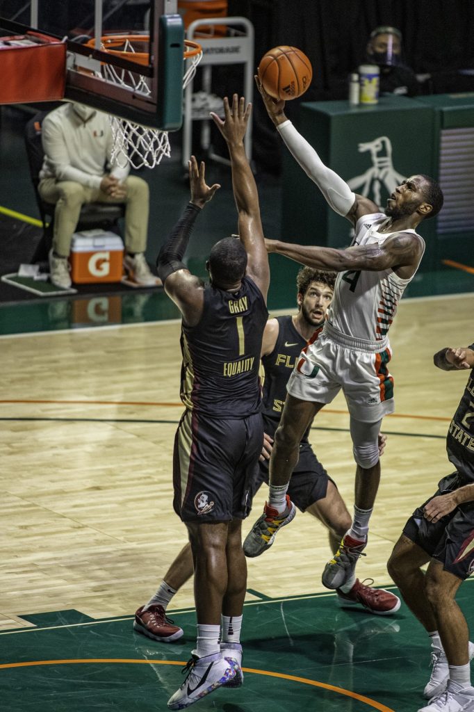 Senior Elijah Olaniyi attempts to make a layup over a Florida State defender in Miami's loss on Wednesday Feb. 24 at the Watsco Center. Miami finished the season with a 10-17 record while only winning four of their 19 conference games.