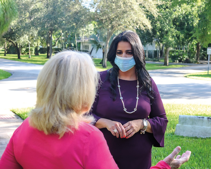 Claudia Miro talks with a voter in Coral Gables.