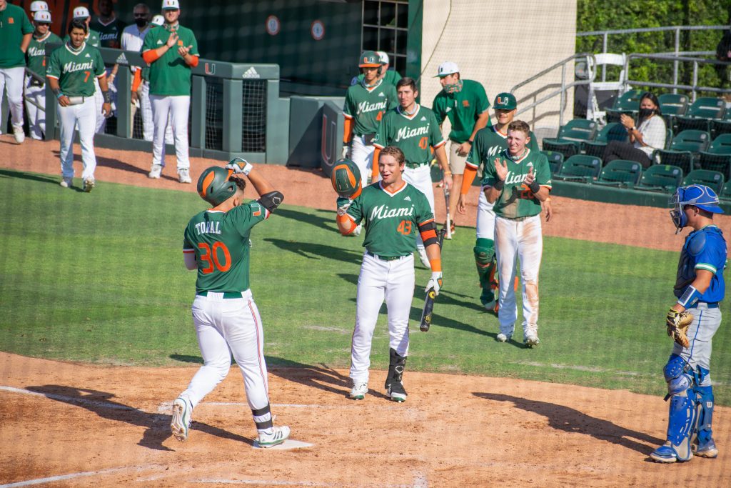 Gabe Rivera (43) greets teammate Alex Toral (30) after the first baseman hit a home run against FGCU on April 14 at Mark Light Field.