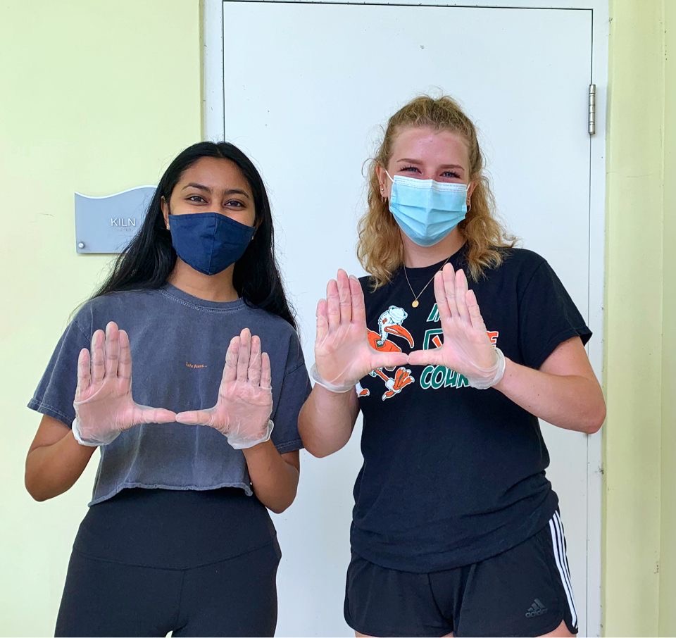 Melanie Veerasammy (left) and Jill Ingram (right) take a break from bleaching and washing shower curtains at the Lotus House to throw up the U.
