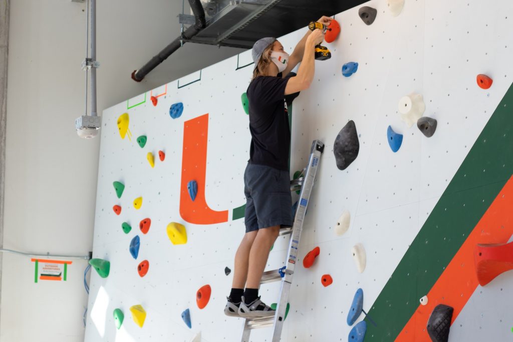 Sophomore Trey Riera-Gomez adjusts the course at the new climbing/bouldering wall in Lakeside Village on Oct. 14, 2020. The climbing wall is open to all members of the UM community.
