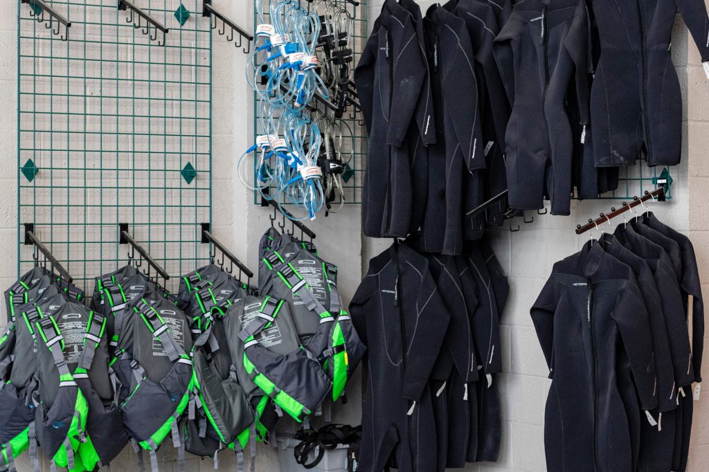 Wetsuits, lifejackets, and other aquatic equipment hang on the walls of Outdoor Adventures April 5. Rental equipment can be reserved by any member apart of the UM community.
