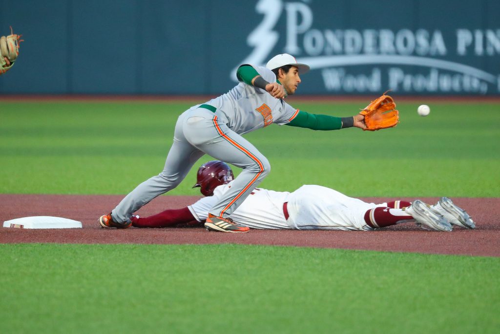 Anthony Vilar attempts to catch the baseball at second base while a Boston College slides into the base. The Hurricanes lost 13-0 at