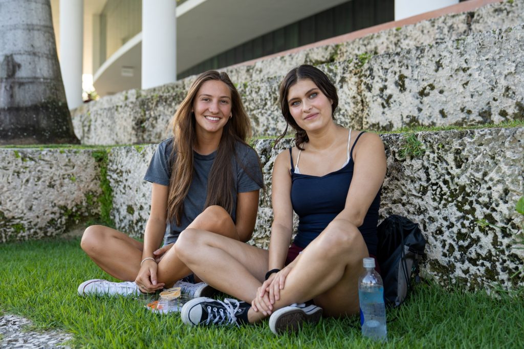 Freshmen Valentina Urbicain and Isabel Briones, majoring in Architecture and Broadcast Journalism respectively, sit by Lake Osceola on Aug. 19, 2021.