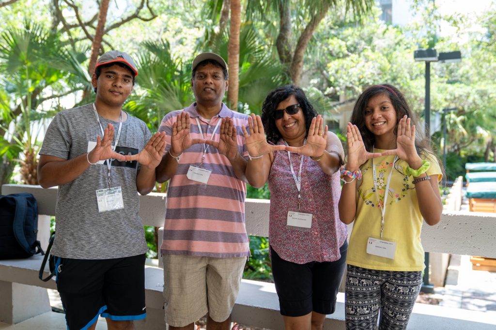 Yasith Yapa (left) and family throw up the U while moving into Hecht Residential College on Aug. 17, 2021.