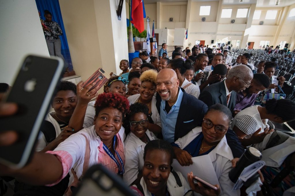 Dean Henri Ford, center, poses for a photo with people in Haiti. Ford is a Haitian-born pediatric surgeon who maintains close ties with his native country. In 2010 he traveled to Haiti after the earthquake to provide surgical care to children injured in the disaster.  Ford regularly returns to Haiti  to provide medical care to its residents.