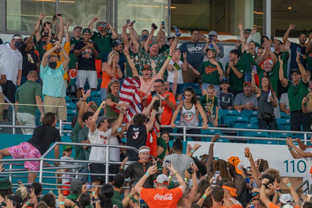 Fans celebrate after a cat survived a fall from the 300 level seating area, aided by an American flag outstretched by UM fans, during the first half of Miami’s game versus Appalachian State at Hard Rock Stadium on Sept. 11, 2021.