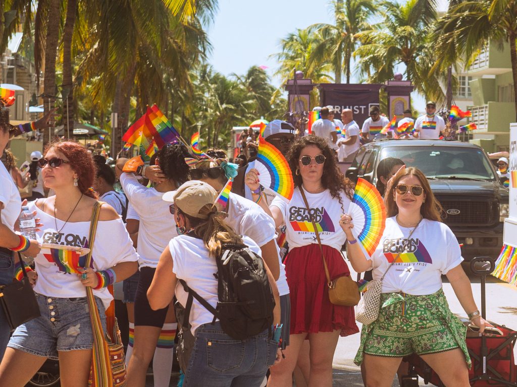 Supporters of the LGBTQIA+ community in Miami Beach celebrate with colorful gear along Ocean Drive