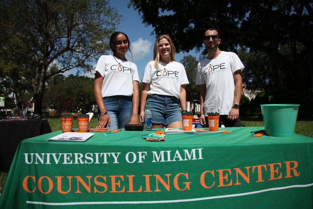 Leaders of UM's Counseling Outreach Peer Organization, or COPE, stand at a table in the middle of UM's Coral Gables campus during an event Wednesday, Oct. 6.