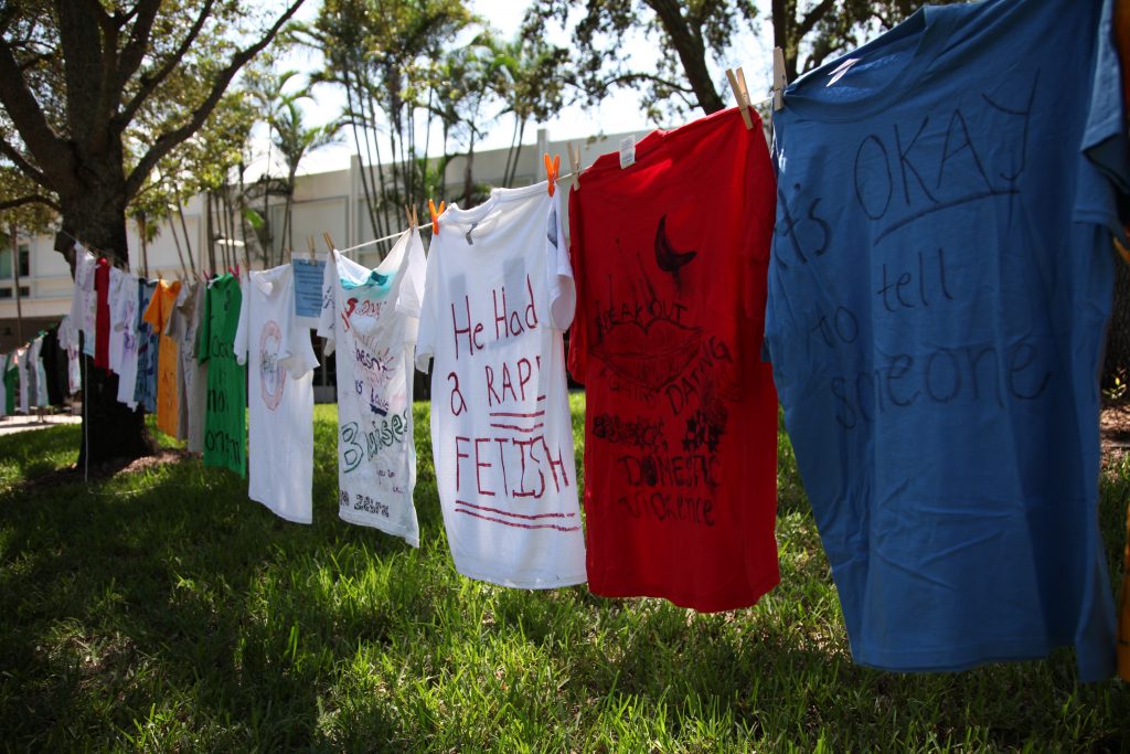 Shirts with various messages related to gender-based violence line the walkway next to 'The U' statue on UM's Coral Gables campus Wednesday, Oct. 6.