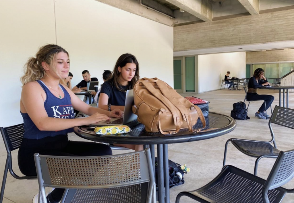 Students outside the Cox Science Building auditorium work on their laptops Tuesday, Sept. 27. University of Miami Information Technology recently added more wireless access points to that area.