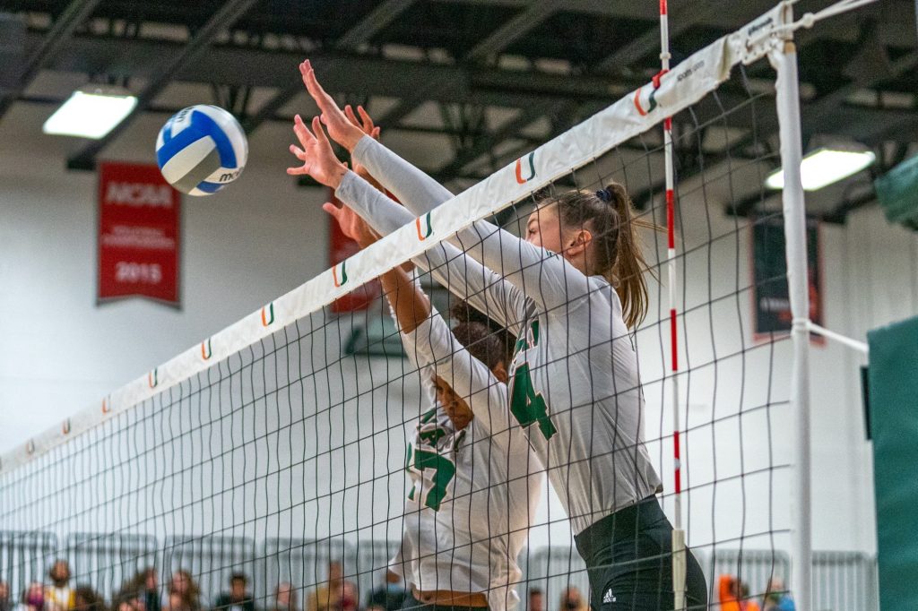Redshirt sophomore outside hitter Angela Grieve and junior middle blocker Janice Leao reach up to block a shot in the third set of Miami’s match versus the University of North Carolina in the Knight Sports Complex on Oct. 1, 2021.