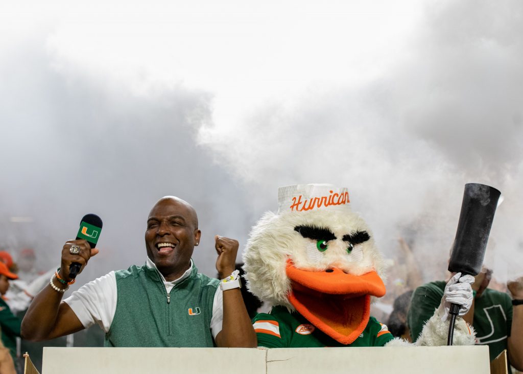 Hurricanes host Dale McLean and Sebastian the Ibis dance during the student section smoke after the end the first quarter of Miami’s game versus Virginia Tech at Hard Rock Stadium on Nov. 20, 2021.