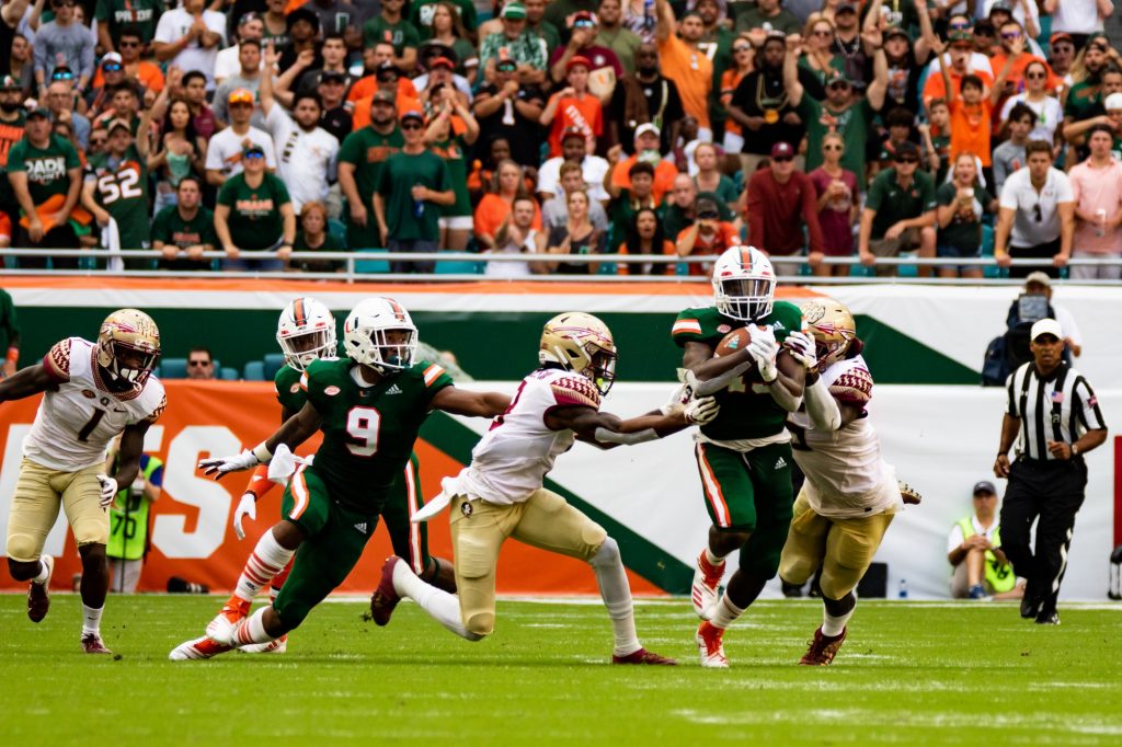 Former UM running back DeeJay Dallas, then a sophomore, runs through Florida State defenders on Oct. 6, 2018 at Hard Rock Stadium. Miami won 28-27.