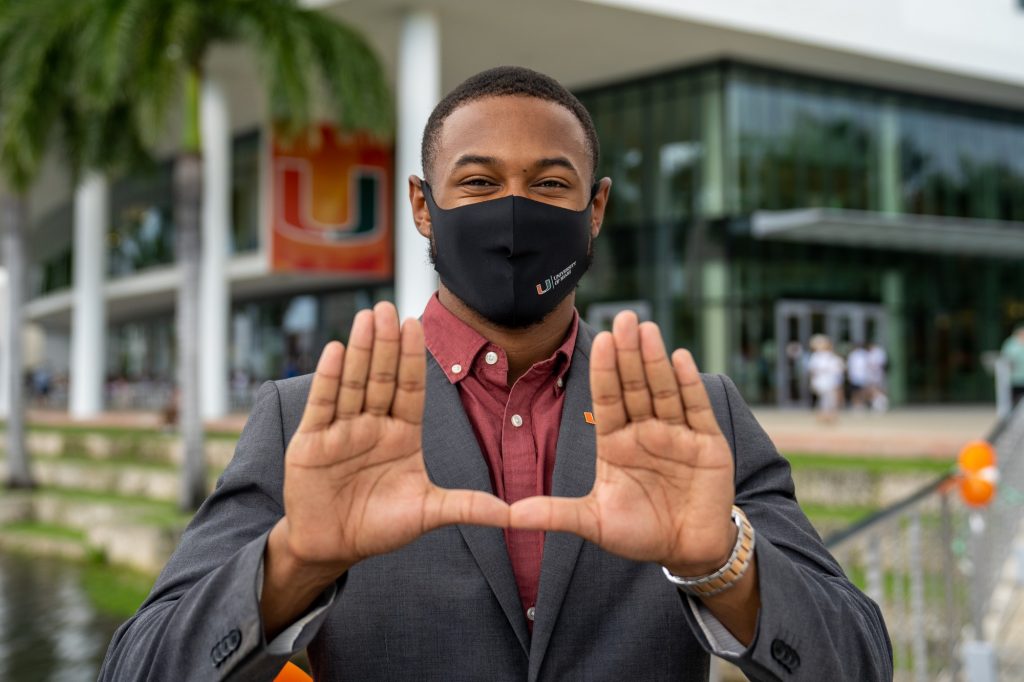 Student government President Landon Coles throws up the U in front of the Shalala Student Center during Family Weekend on Sept. 25, 2021.