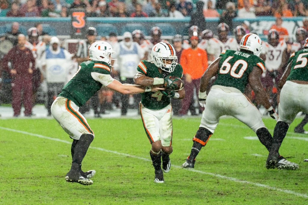 Freshman quarterback Tyler Van Dyke hands off the ball to freshman running back Jaylan Knighton during the second quarter of Miami’s game versus Virginia Tech at Hard Rock Stadium on Nov. 20, 2021.
