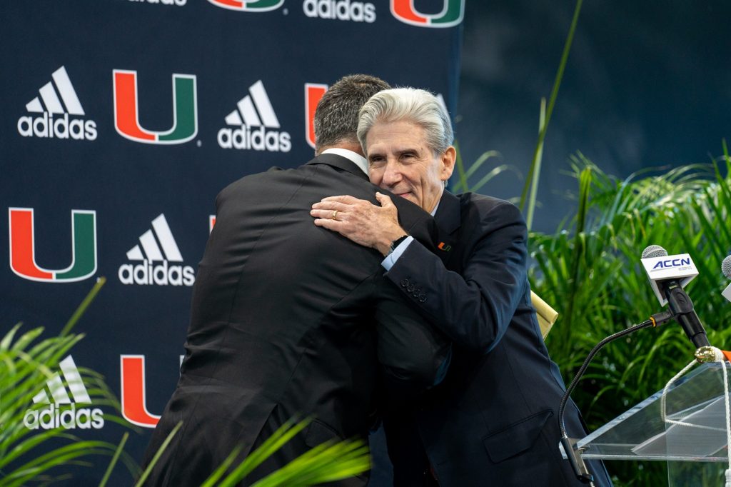 President Julio Frenk embraces Head coach Mario Cristobal as he welcomes him to the stage in the Carol Soffer Indoor Practice Facility on Dec. 7, 2021.