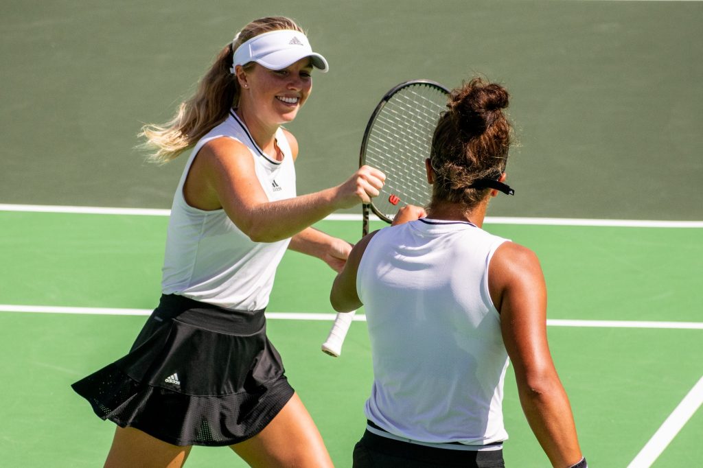 Fourth-year junior Daevenia Achong and fifth-year senior Eden Richardson celebrate on-court in No. 23 Miami's 6-0 doubles victory against No. 17 Old Dominion on Saturday, Feb. 5, 2022 at the Neil Schiff Tennis Center.