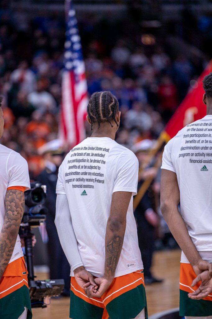 Sixth-year redshirt senior Kameron McGusty looks towards the American flag before Miami's matchup against Kansas in the Elite Eight. Miami wore warmup t-shirts in support in support of Title IX.