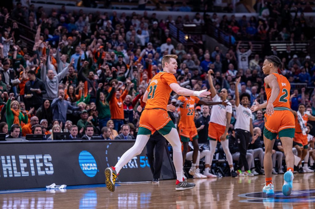 Sixth-year redshirt senior Sam Waardenburg high-fives third-year sophomore Isaiah Wong after hitting a three point shot during the first half of Miami's Elite Eight matchup against Kansas at the United Center on Sunday, March 27, 2022.