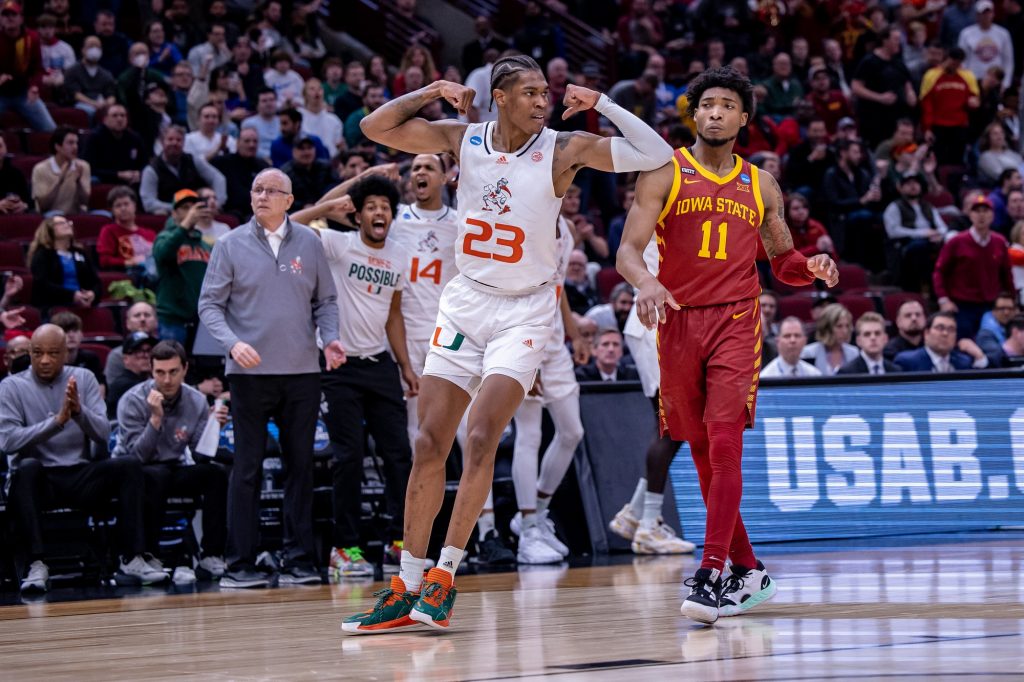 Sixth-year redshirt senior Kameron McGusty flexes while the Hurricanes bench celebrates behind him after hitting a shot in Miami's 70-56 win over Iowa State in the Sweet 16 at the United Center in Chicago on Friday, March 25, 2022.