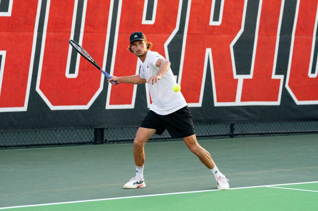 Fifth-year senior Benjamin Hannestad returns the ball during the fifth game of the first set of his singles match versus senior Mac Kieger at the Neil Schiff Tennis Center on March 11, 2022.
