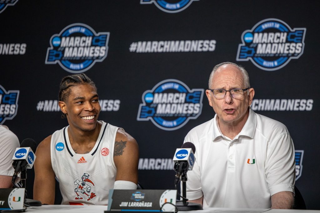 Sixth-year redshirt senior Kameron McGusty smiles while head coach Jim Larrañaga makes remarks after Miami's victory over Iowa State in the Sweet 16 at the United Center in Chicago on Friday, March 25, 2022.