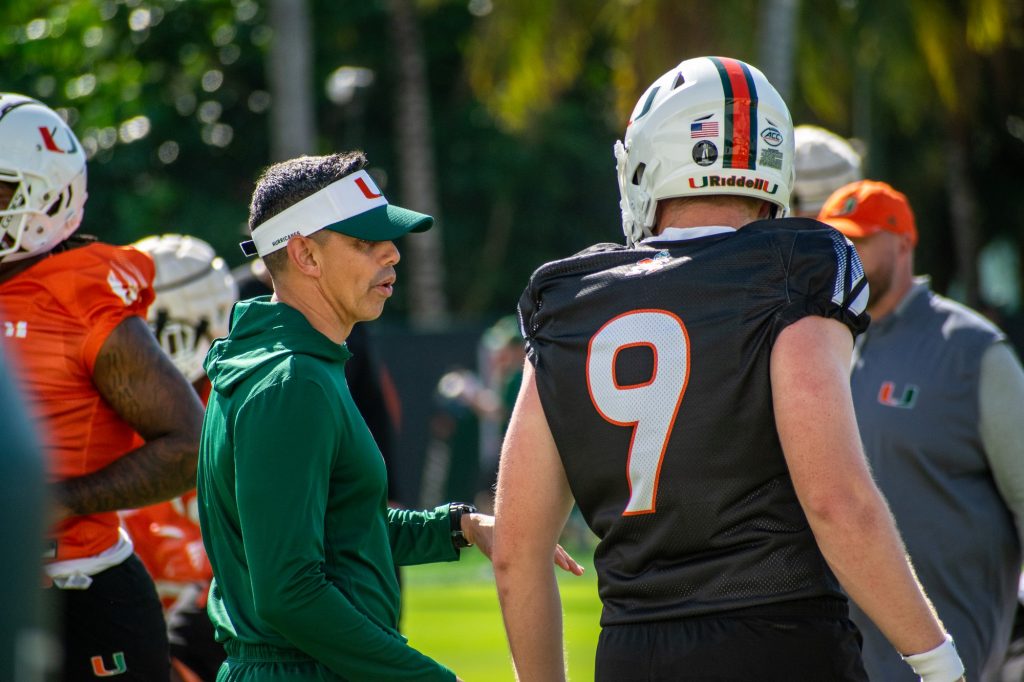 Quarterbacks coach Frank Ponce and sophomore Tyler Van Dyke discuss in Miami's spring practice on Friday, March 11, 2022 on Greentree practice field.
