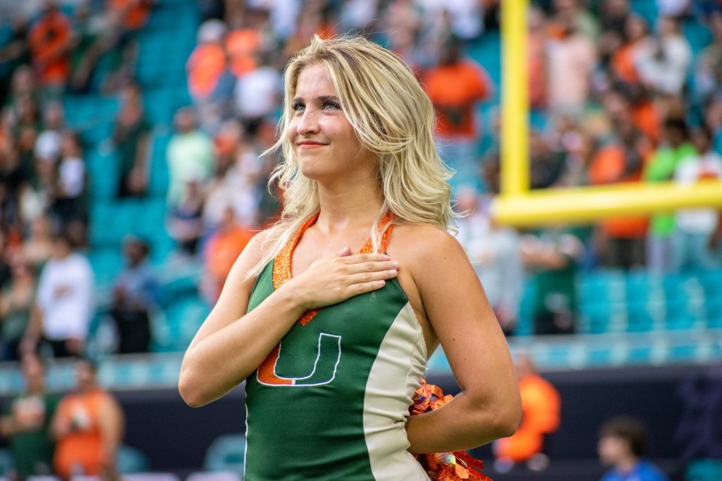 A Hurricanette dancer stands with her hand over her heart during the National Anthem prior to Miami's game against Duke University on Saturday, Oct. 22 at Hard Rock Stadium.